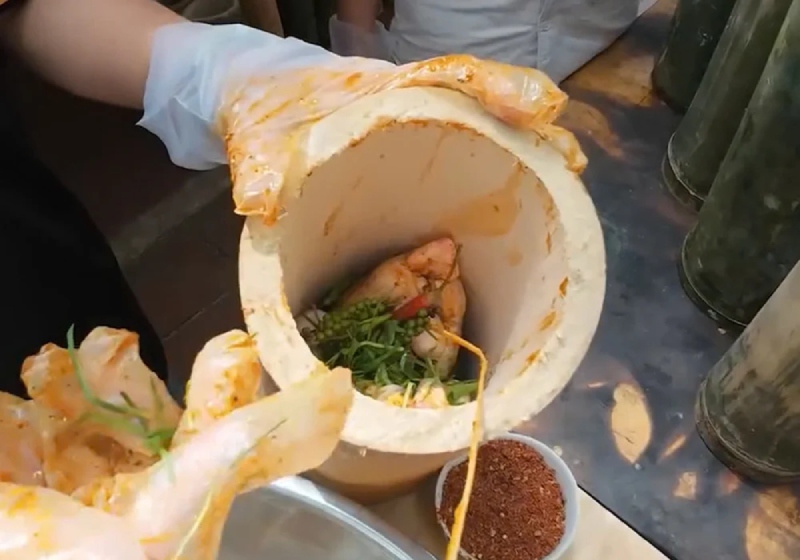 nhồi gà vào ống tre chuẩn bị nướng