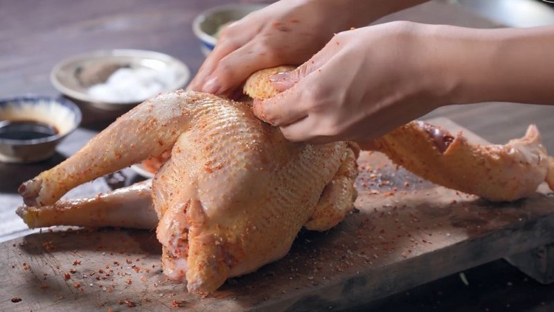 Ướp gà kỹ với sốt và gia vị trước khi quay