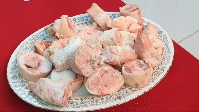 Giò heo được chặt khúc và tẩm ướp chuẩn bị chế biến
