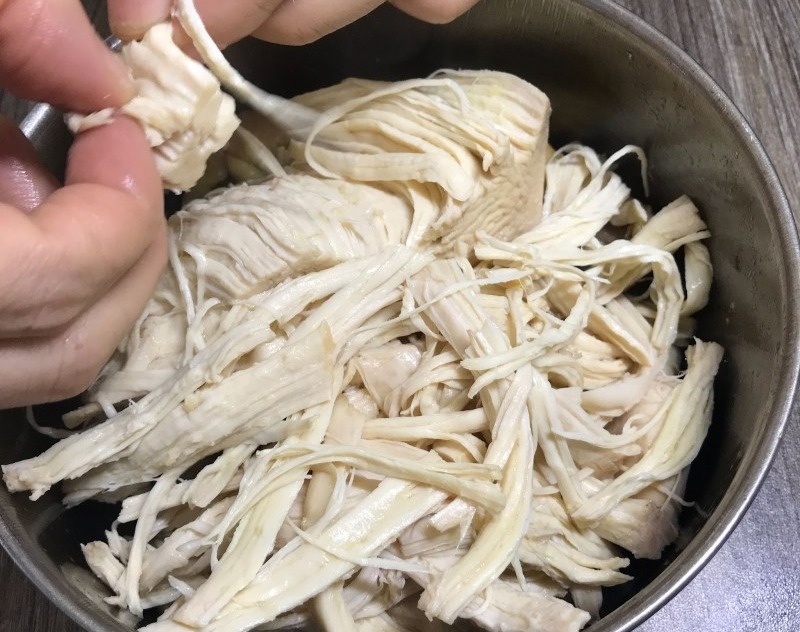 Xé nhỏ thịt gà đã luộc chín bằng tay