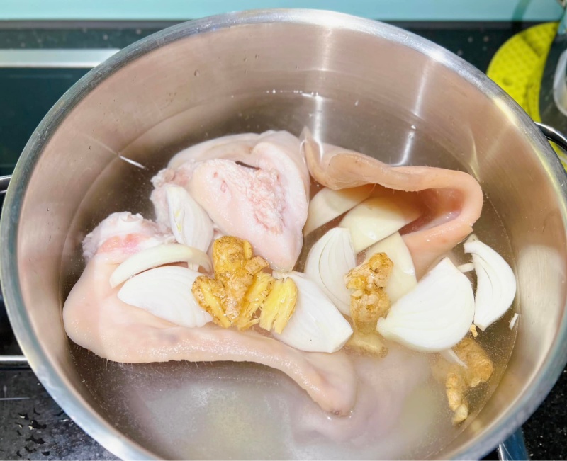 Luộc tai heo với gừng và hành để khử mùi