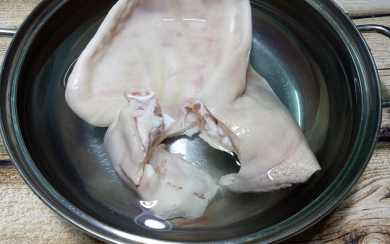 Tai heo được luộc chín để chuẩn bị làm gỏi