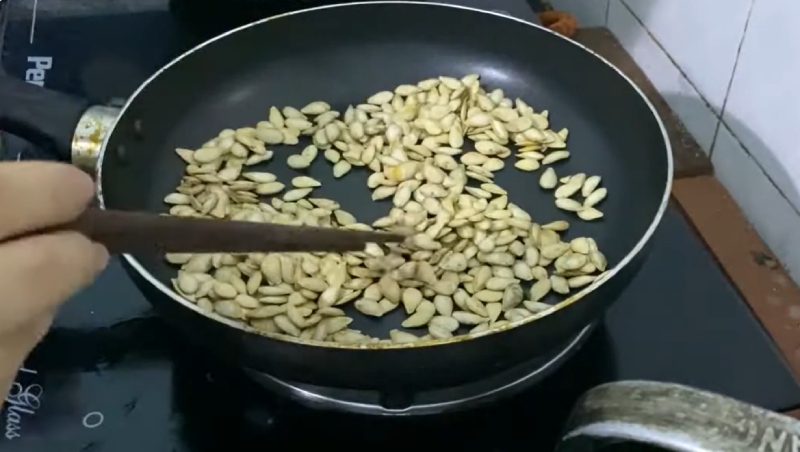 Rang hạt bí trên chảo nóng