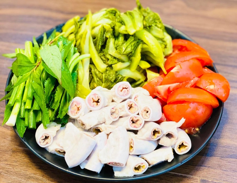 Lòng heo luộc thái miếng kèm dưa chua, cà chua và rau thơm