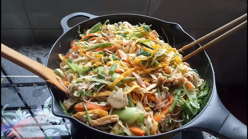 Mì chay đã luộc và đổ vào chảo đã xào