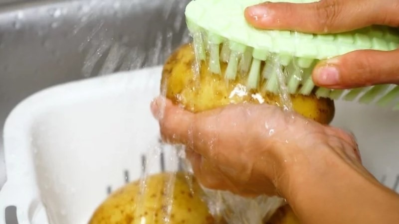 Cọ rửa khoai tây dưới vòi nước