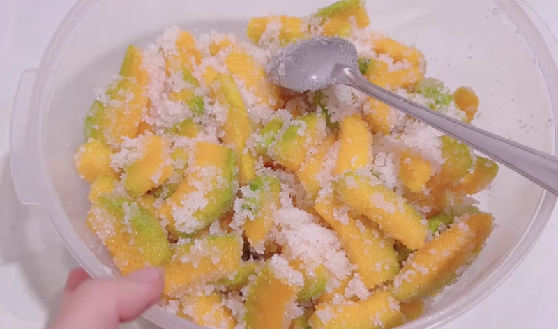 Trộn bí đỏ với đường và ướp đến khi đường tan