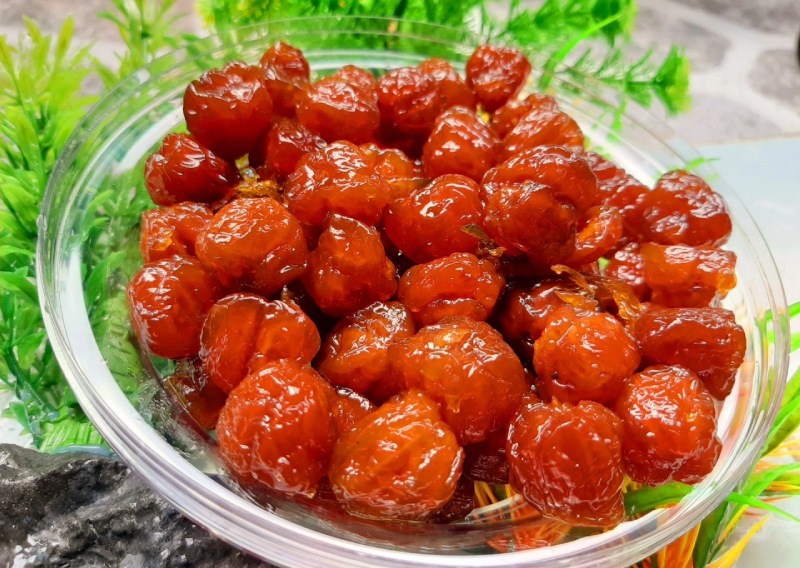 Mứt sơ ri thành phẩm màu đỏ óng trong hộp nhựa