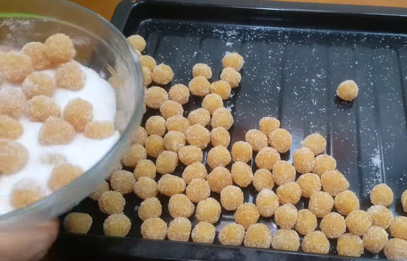 Nặn mứt thơm thành hình tròn và phủ lớp đường