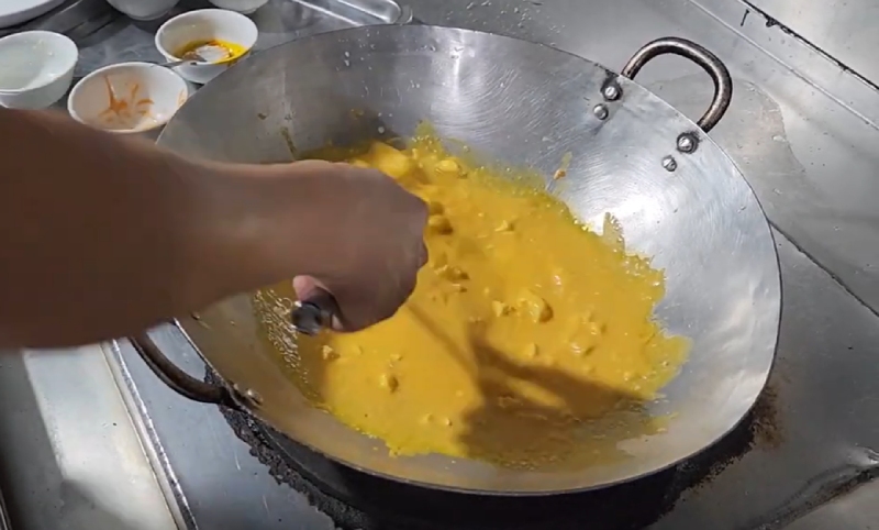 Đun trứng muối trong chảo để làm sốt hoàng kim