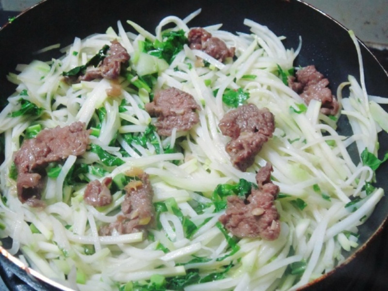 cho thịt bò vào chảo su hào và xào chung