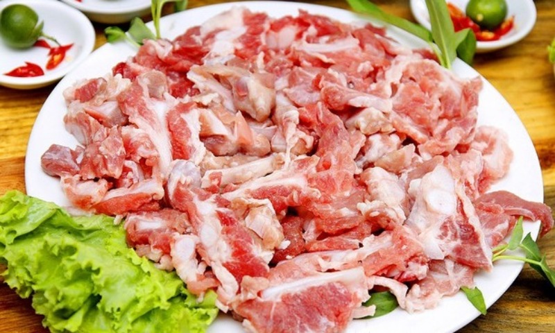 Sườn sụn heo sống được bày ra đĩa, kèm rau ăn kèm