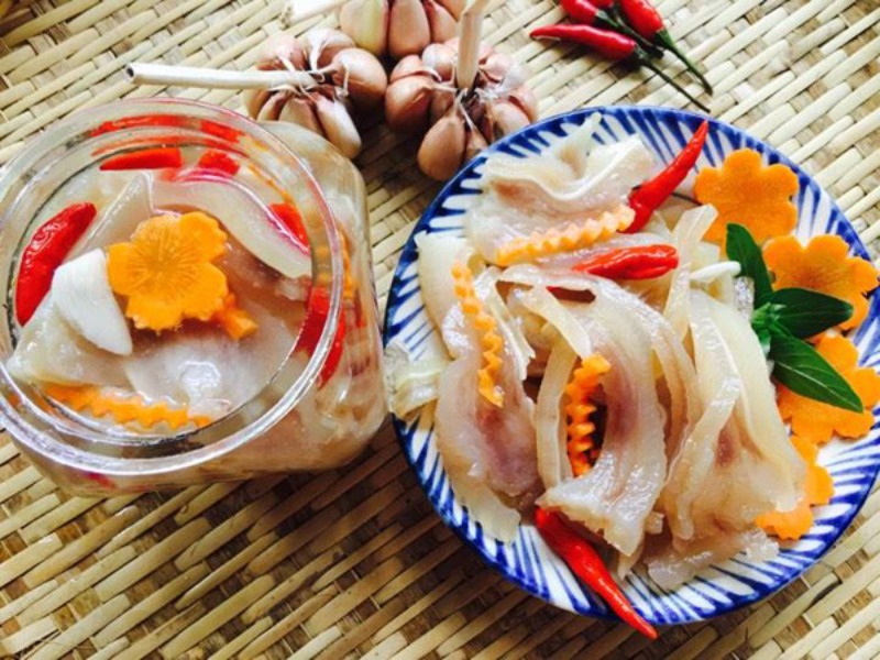 Tai heo ngâm giấm tỏi ớt trong hũ thủy tinh và đĩa sứ.
