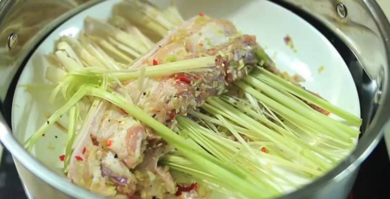 Cho sả chẻ nhỏ vào xửng, rồi đặt thịt heo lên hấp