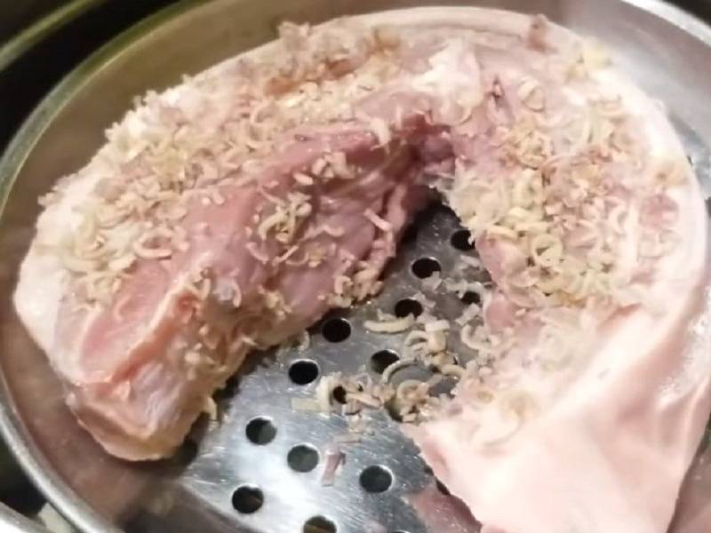 Cho thịt heo đã ướp vào xửng hấp