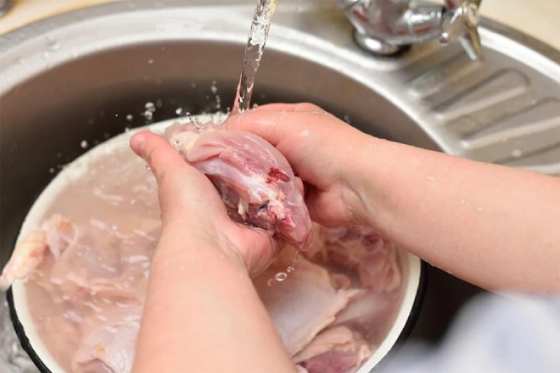 Rửa sạch tim heo dưới vòi nước