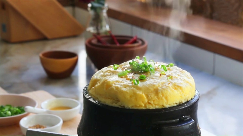 Trứng hấp bông mềm trong nồi đá, rắc hành lá trang trí
