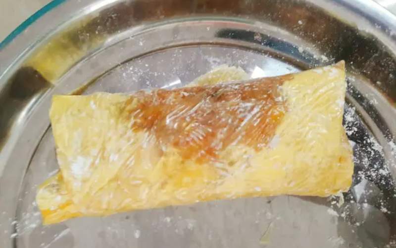 Lấy đậu hũ đã ướp, úp mặt ngoài xuống, xếp nấm lên và cuộn chặt