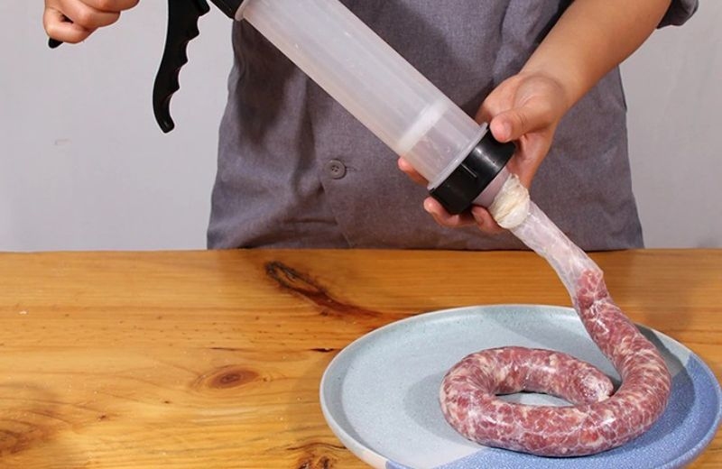 Dùng dụng cụ chuyên dụng để nhồi thịt vào vỏ