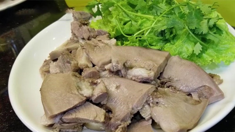  Lưỡi heo sau khi luộc được thái lát và bày ra đĩa kèm rau sống.