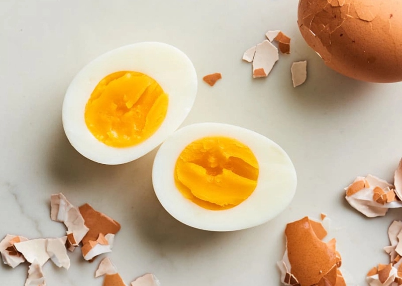 Trứng luộc bóc vỏ, cắt đôi cùng vỏ trứng xung quanh