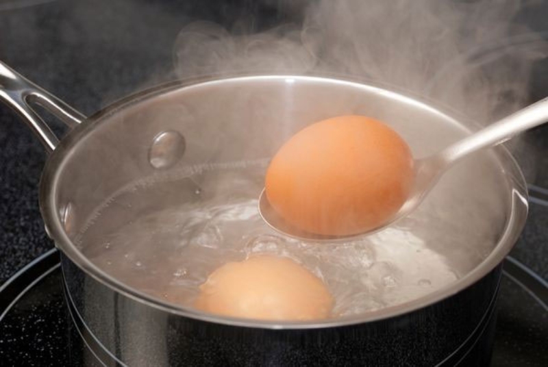 Dùng muỗng vớt trứng gà ra khỏi nồi nước sôi