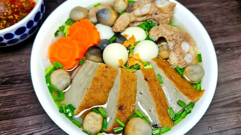Tô bánh canh bột lọc đầy đủ với chả, trứng cút, nấm, cà rốt và xương heo hầm