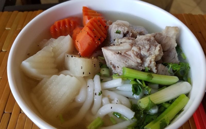 Tô bánh canh sườn heo với cà rốt, củ cải, hành lá và tiêu đen