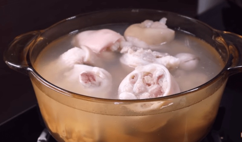 Giò heo đang được hầm mềm trong nồi nước dùng.