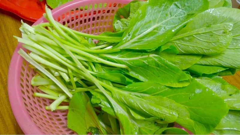 rửa sạch cải xanh chuẩn bị cắt nhỏ