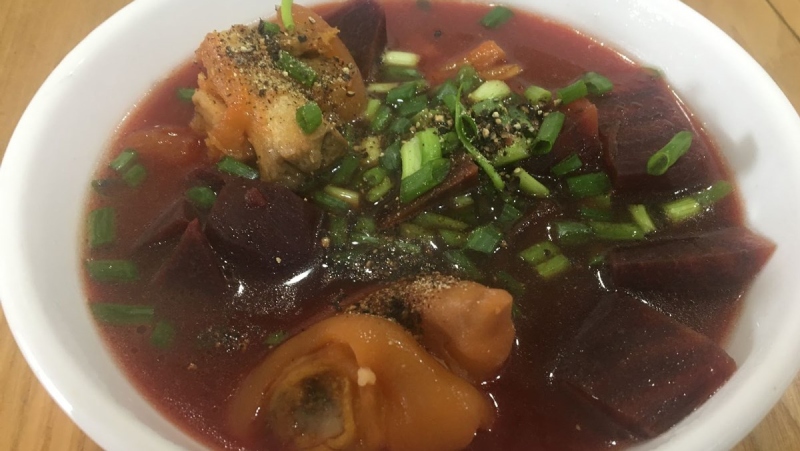 Thành phẩm canh giò heo củ dền rắc hành lá và tiêu