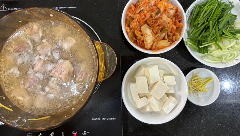 Nồi nước dùng sườn heo đang nấu và các nguyên liệu