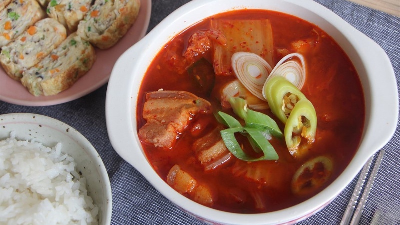 Canh kim chi thịt heo được múc ra tô và ăn kèm với cơm