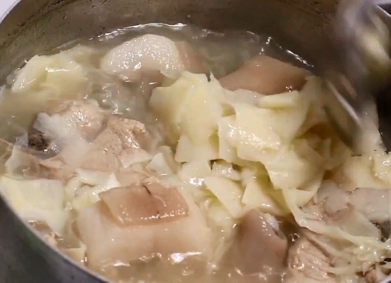 Nồi canh đang hầm đuôi heo và măng thái sợi.
