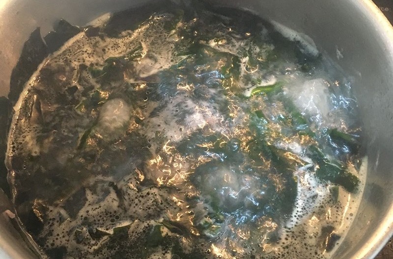 Nồi canh rong biển đang sôi trên bếp với xương heo và rong biển