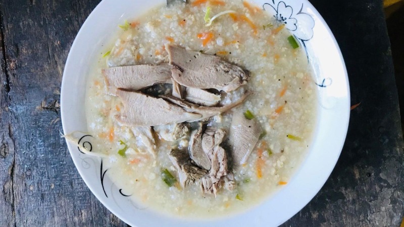 Múc cháo ra tô, rắc thêm hành lá, ngò rí và tiêu