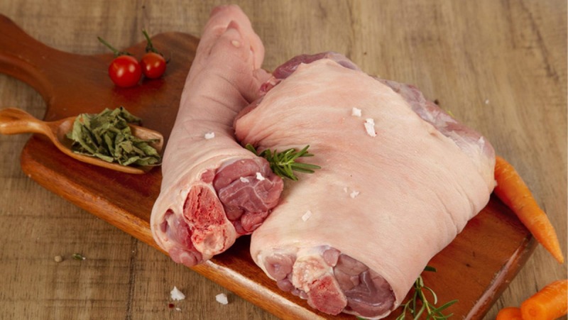 Chân giò heo tươi còn nguyên miếng trên thớt gỗ