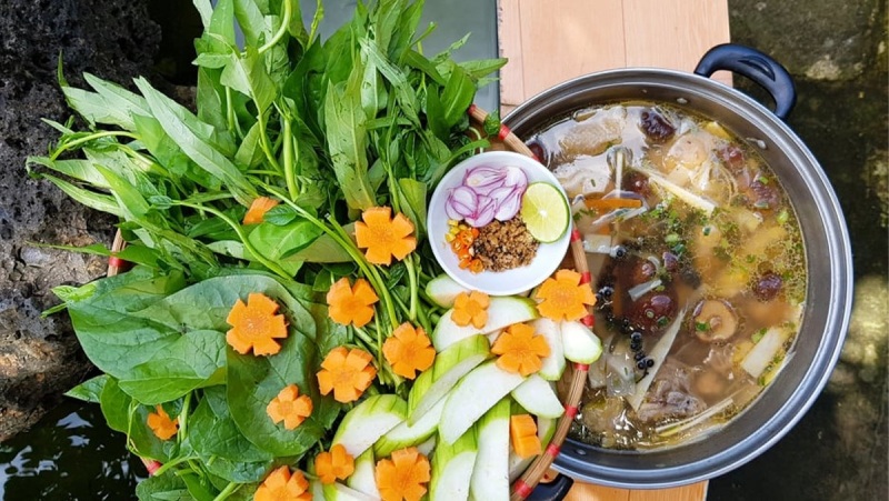 Nồi lẩu gà măng cay đã hoàn thành, bày biện cùng rau ăn kèm 