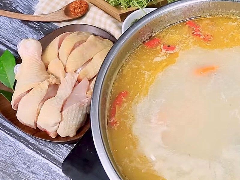 Nước lẩu gà vàng óng, đĩa gà sống để nhúng lẩu