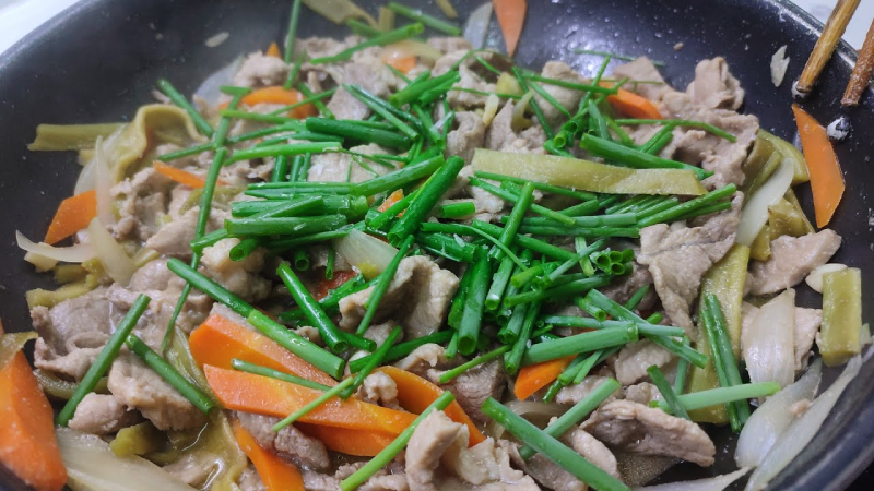 Cho rau tiến vua vào xào chung với thịt heo