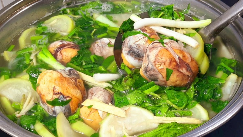 Trứng vịt lộn um bầu đang sôi trong nồi, thêm hành và gừng
