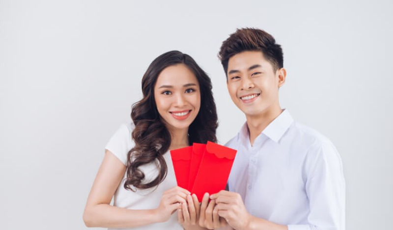 Cặp đôi cầm phong bao lì xì ngày Tết