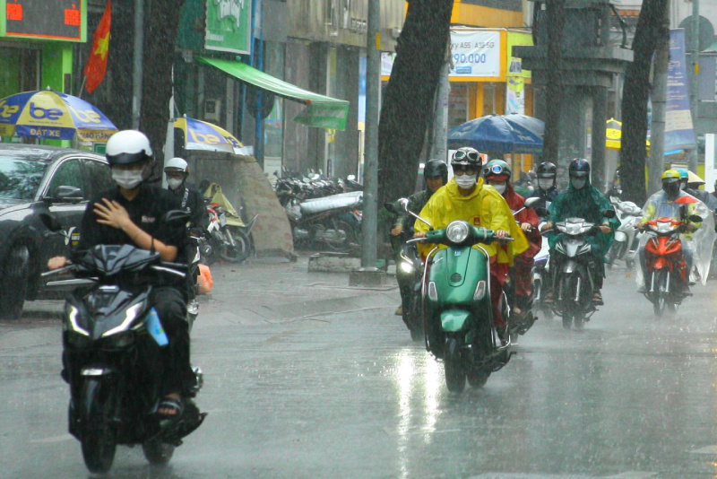Người đi xe máy mặc áo mưa trong cơn mưa lớn ở TP.HCM