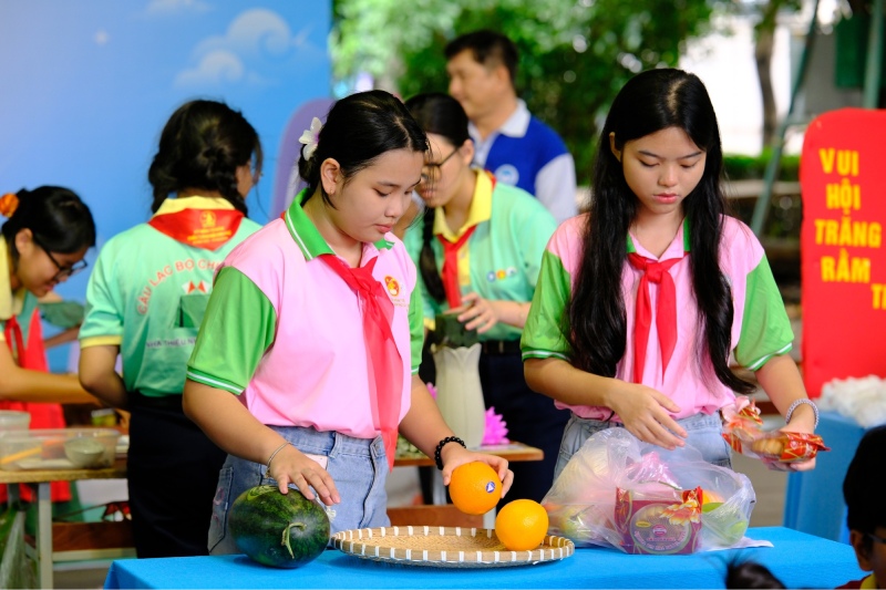 Các bạn học sinh đang chuẩn bị bánh Trung Thu và trái cây