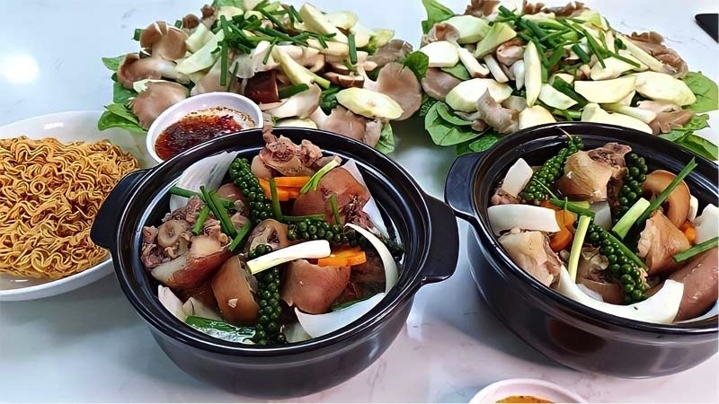 Mâm lẩu đuôi heo ăn kèm với nấm và rau
