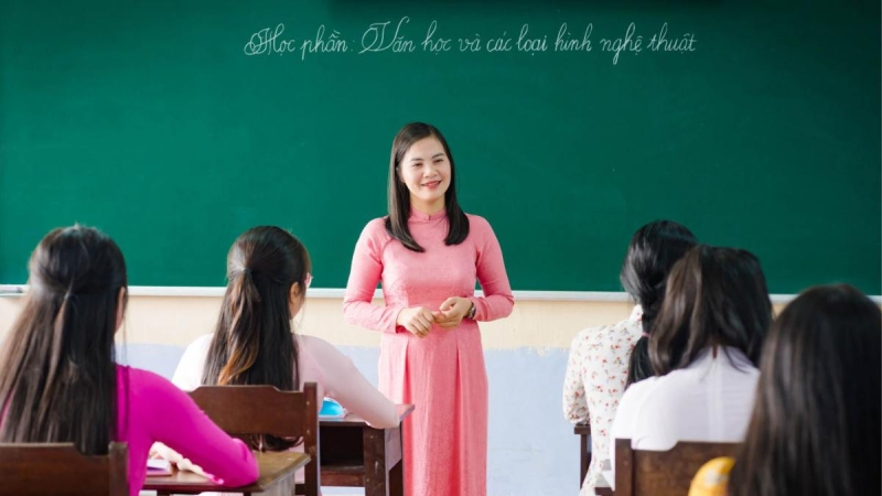 Cô giáo mặc áo dài hồng giảng bài trước lớp