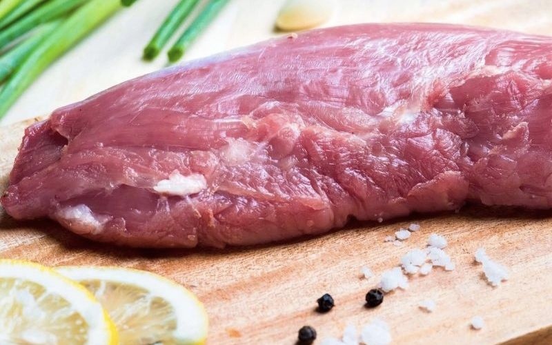Miếng thịt thăn chuột heo tươi sống đặt trên thớt gỗ