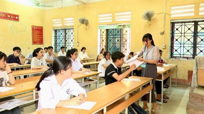 Thi sinh được cô hướng dẫn trước khi làm bài thi