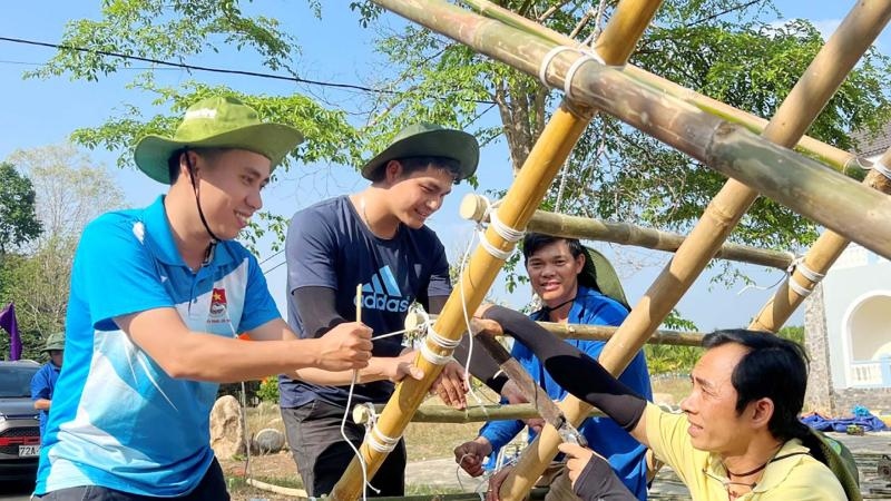 Thanh niên buộc dây cố định khung trại tre ngoài trời