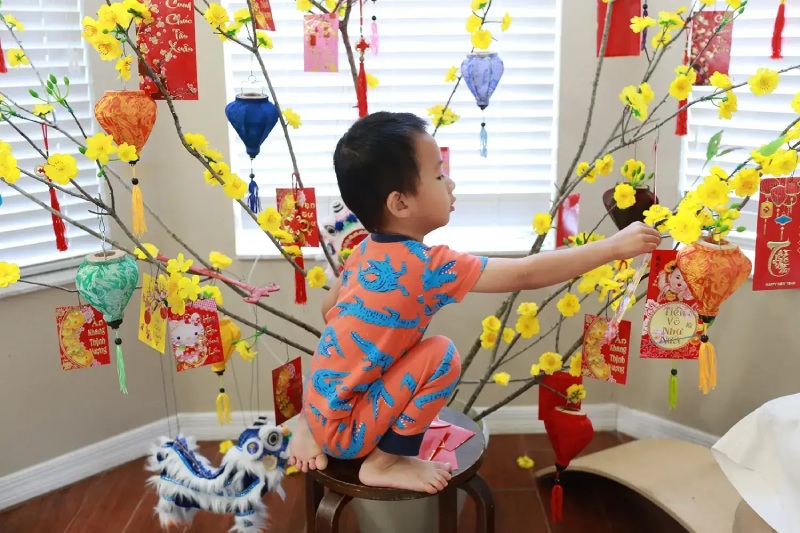 Trang trí lớp học Tết bằng bao lì xì treo cành mai